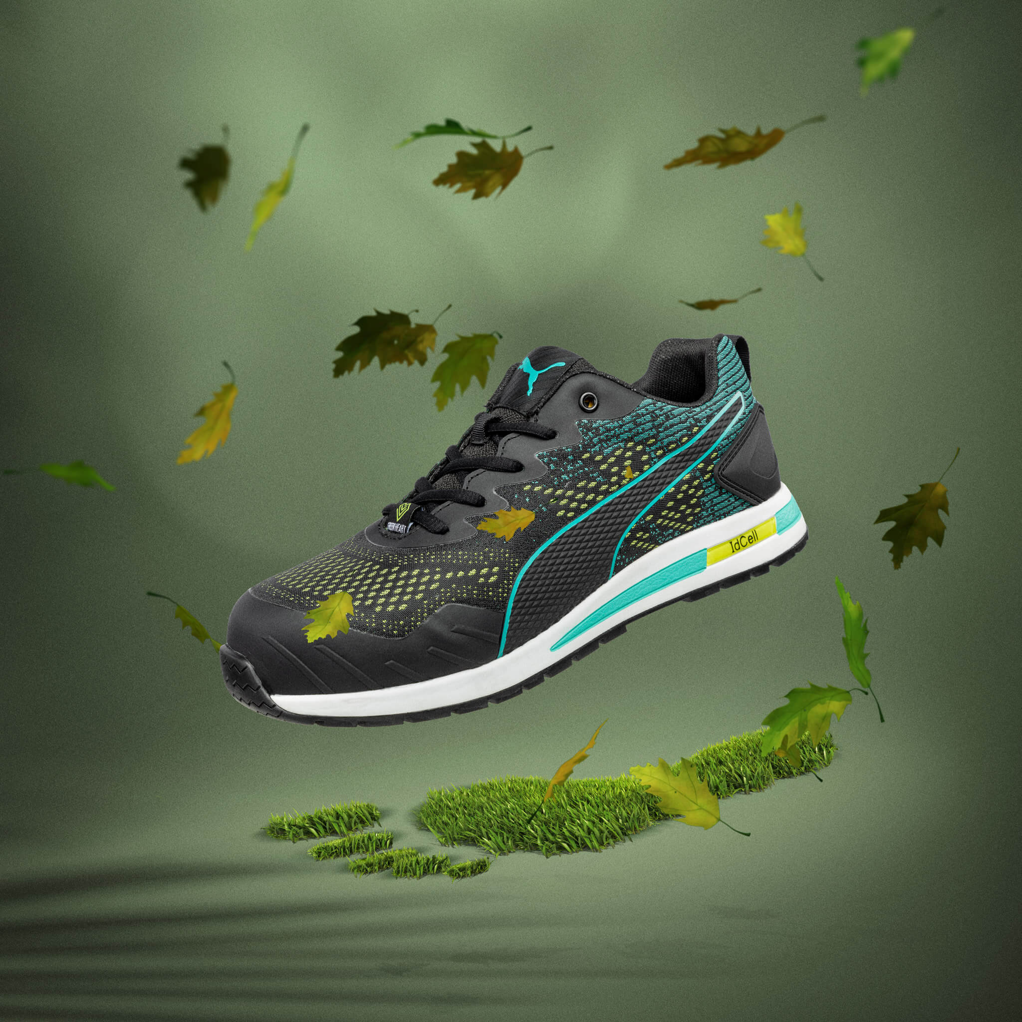 PUMA SAFETY VIVID LOW Sicherheitsschuh S1P ESD in Schwarz mit türkis-gelben Details, präsentiert auf grünem Hintergrund mit fallenden Blättern und grüner Fußabdruck-Silhouette als Symbol für Nachhaltigkeit.
