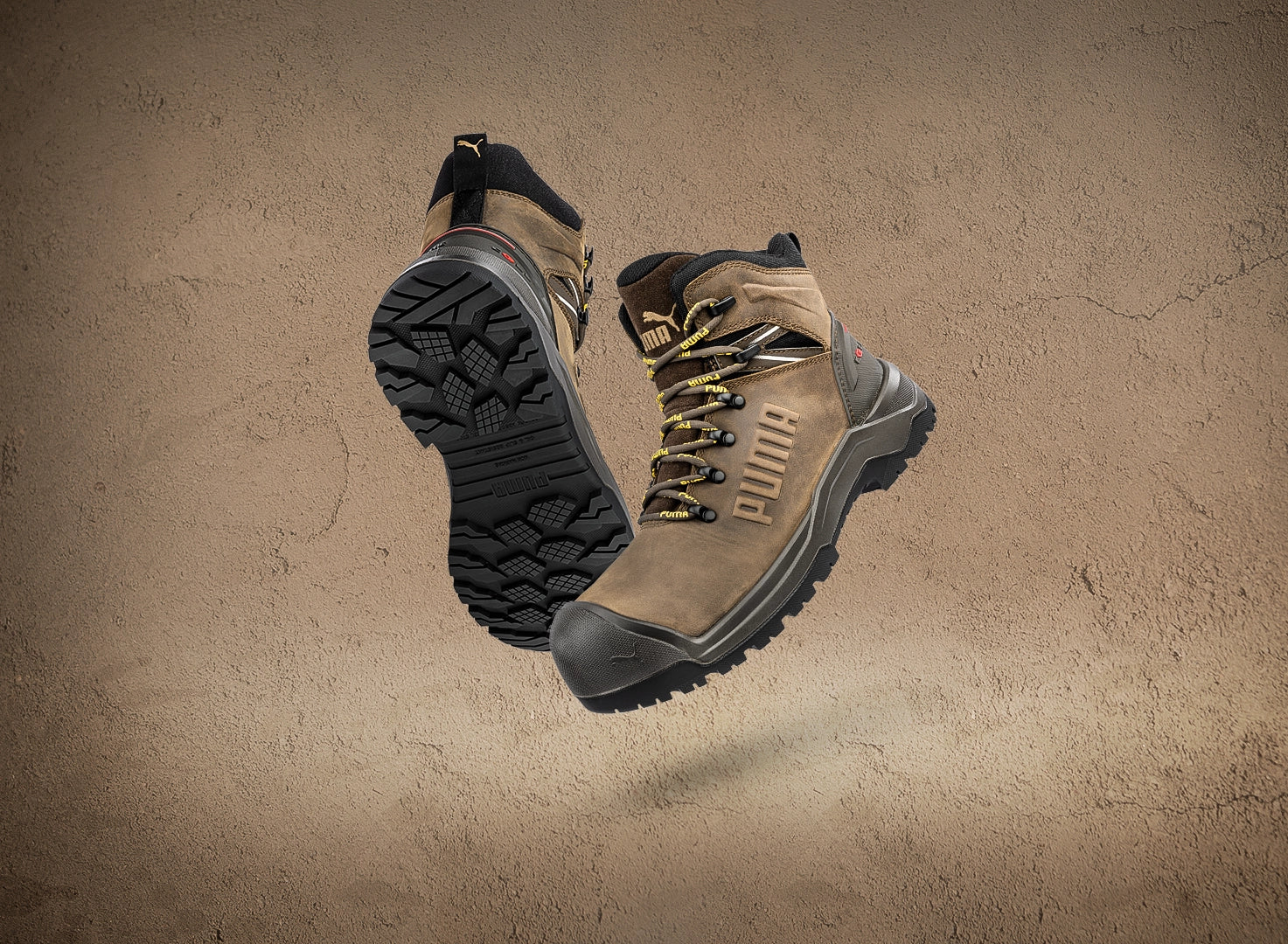 PUMA SAFETY IRON HD MID Sicherheitsschuh S3S in Braun mit schwarzer Profilsohle, Produktaufnahme vor braunen Hintergrund.