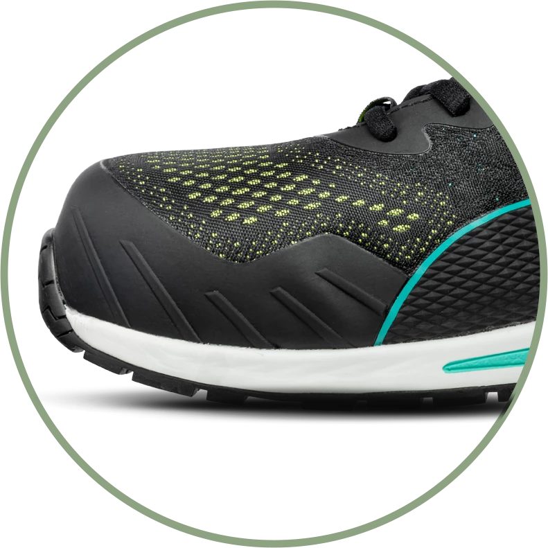 Nahaufnahme der Vorderkappe des PUMA SAFETY VIVID LOW Sicherheitsschuhs S1P ESD in Schwarz mit grünen Details, verstärkter Zehenschutz und zweifarbiger Sohle.